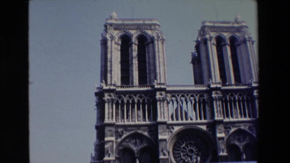 1969 8mm frame holding on Notre Dame's twin towers and Gothic stonework, with the lower portals partly cut off by the frame edge.