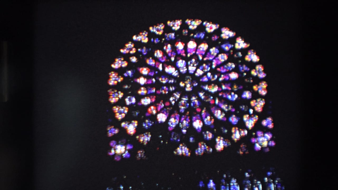 Illuminated rose window glowing against a dark background.