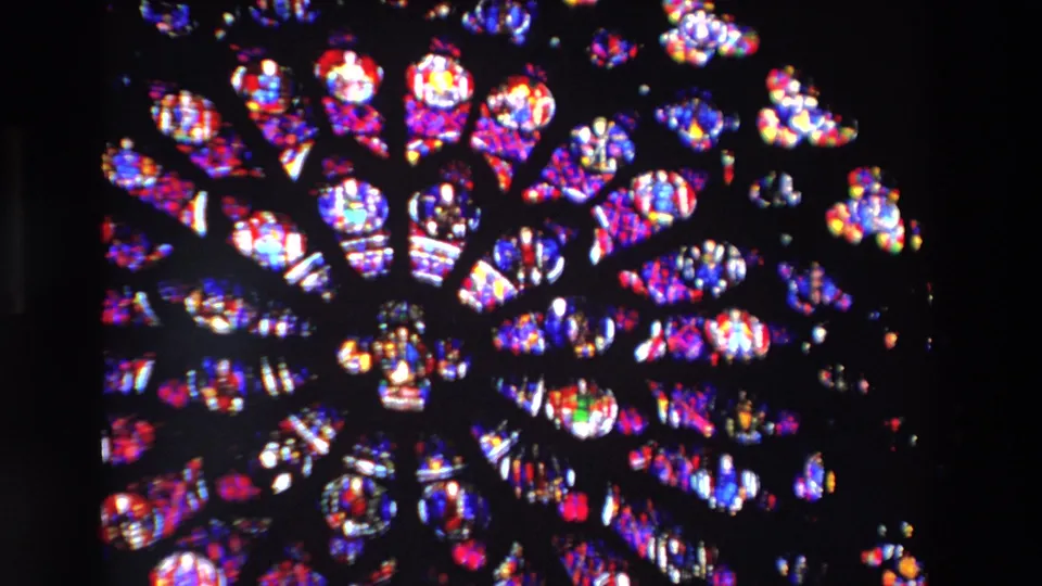 Closer 1969 Paris view of the stained glass rose window, with radial dark tracery and luminous red, blue, purple, green, and white panes.