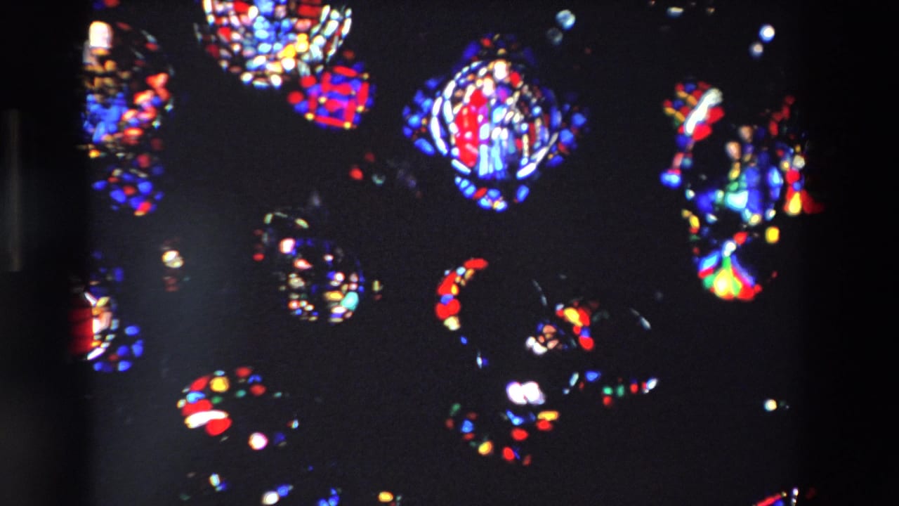 Multiple colored stained glass motifs scattered across a dark frame.