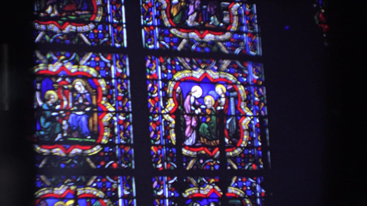 Two stained glass window sections with haloed religious figures and dark framing.