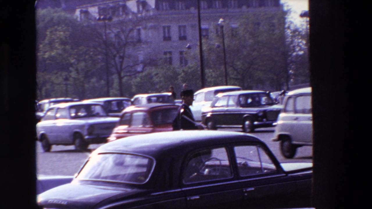 Classic cars move through a busy street with a traffic officer partly visible near the center.