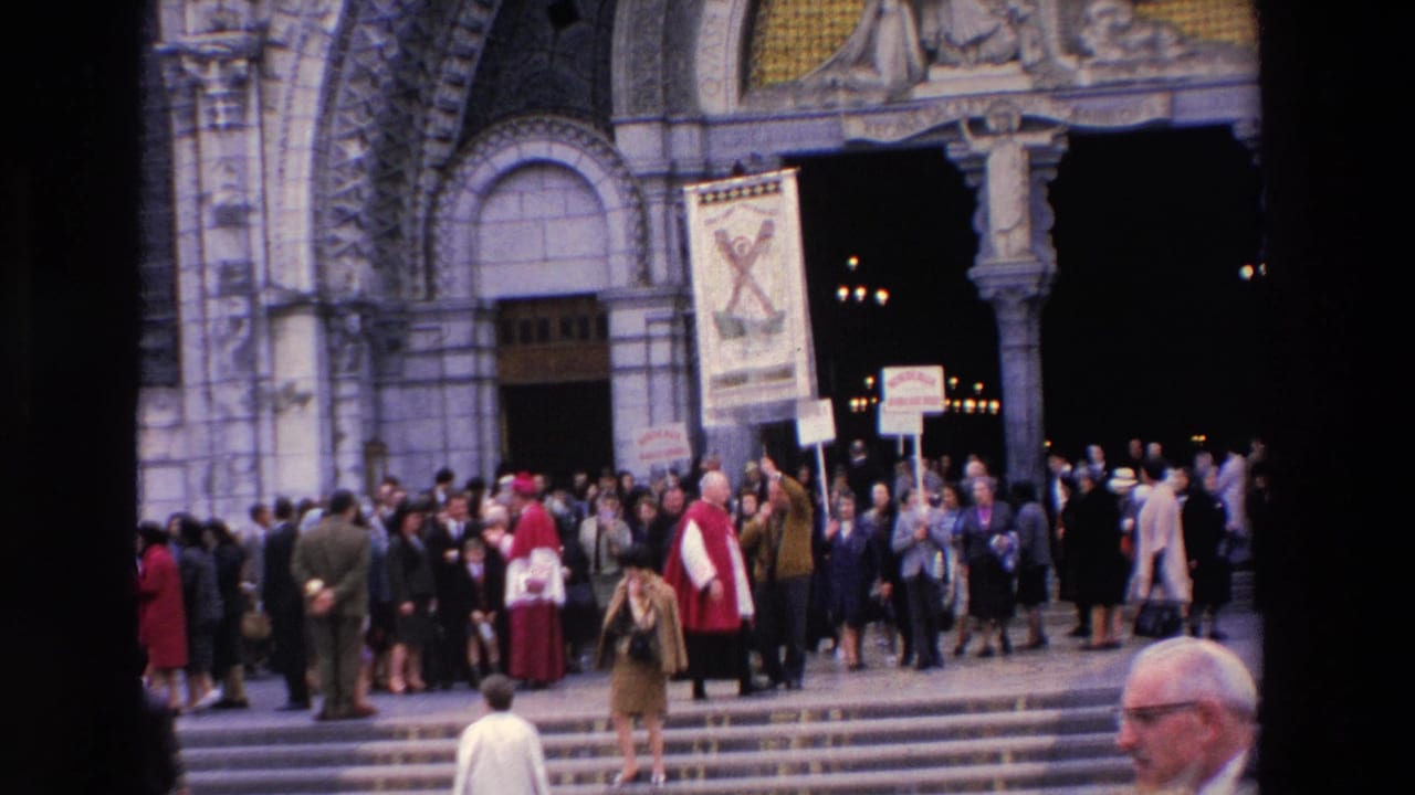 1969 Paris 8mm frame showing a crowd outside an ornate Catholic church entrance, with clergy in red vestments and French signs raised among people on the steps.