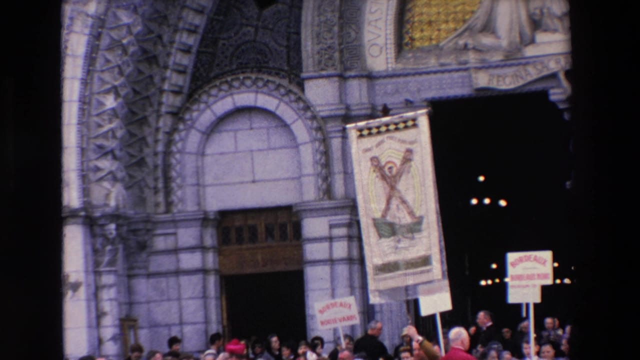 Close view of church archway with a religious banner and protest signs above a crowd.