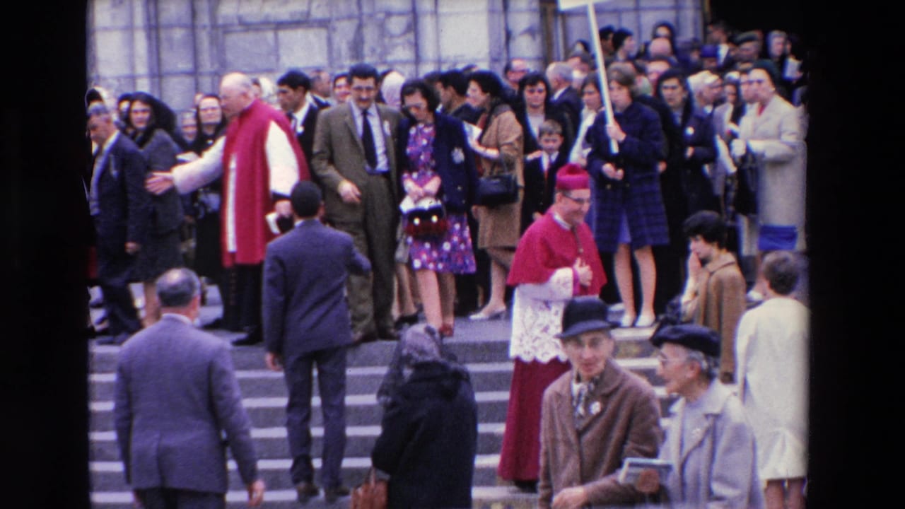 A crowd fills church steps as clergy and pedestrians pass in the foreground.