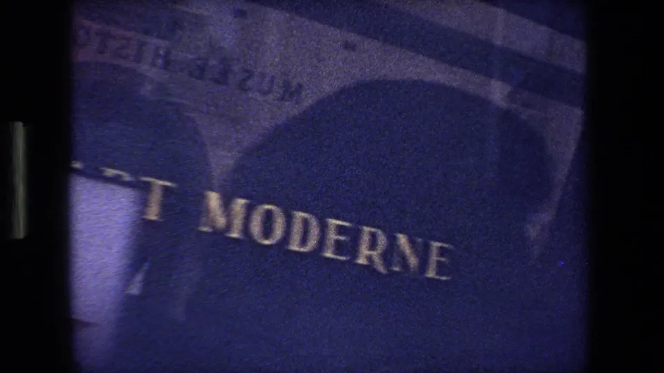 1970 Strasbourg, France 8mm frame showing a dark, grainy close view of a French sign with only part of the lettering readable.