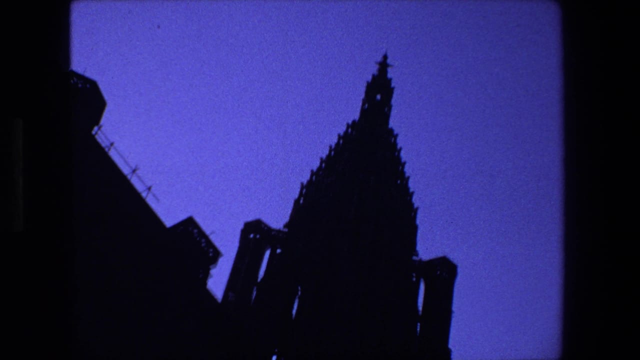 Dark Gothic cathedral spire silhouetted against a blue twilight sky.