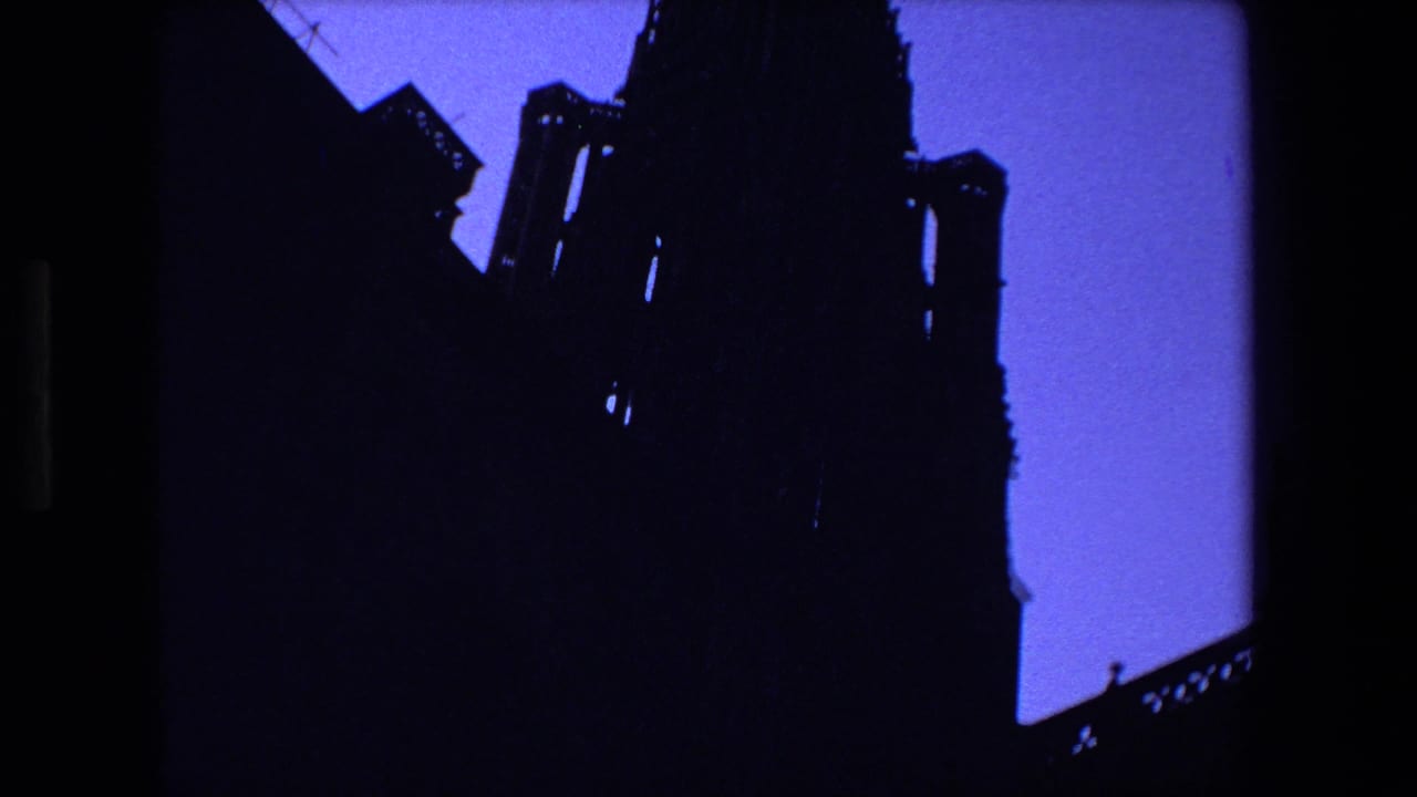 Large cathedral silhouette fills the upper frame against blue sky.