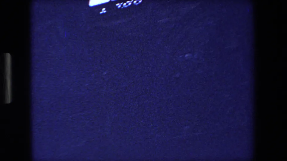 The final sampled frame is largely dark and grainy, with only a small bright edge of the cathedral or roofline visible near the top against the blue exposure.