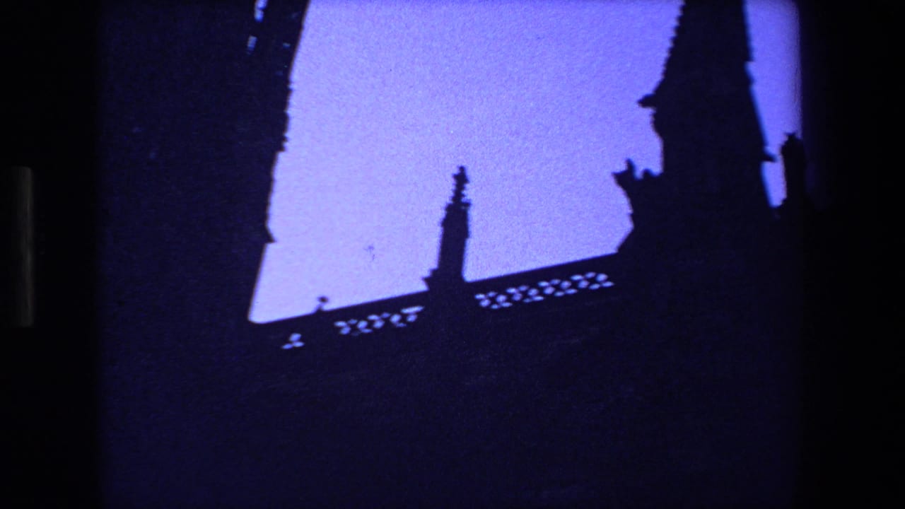 Tall church spire and ornate roof details silhouetted against blue dusk light.