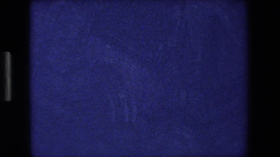 The final 1970 Strasbourg home-movie frame is mostly dark blue grain and shadow, with only faint edge structure visible from the low-light church shot.