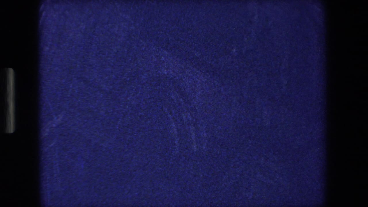 Dark blue leader-like frame with film gate edges and vertical black borders.
