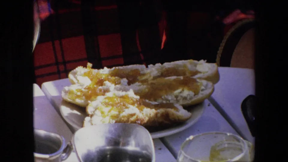 1971 Algeria breakfast-table frame showing bread with spread on a plate, a silver creamer in the foreground, and a glass with orange juice residue.