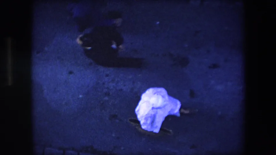 The final frame shows the sheet-covered pedestrian on the dark pavement with a nearby human shadow and the blue-purple cast of the 8mm scan.