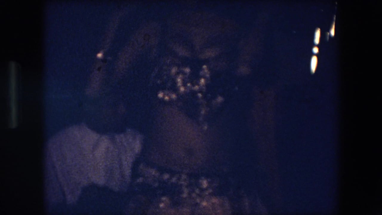 Dark blue interior with a shadowed person and partial figure in a light shirt.