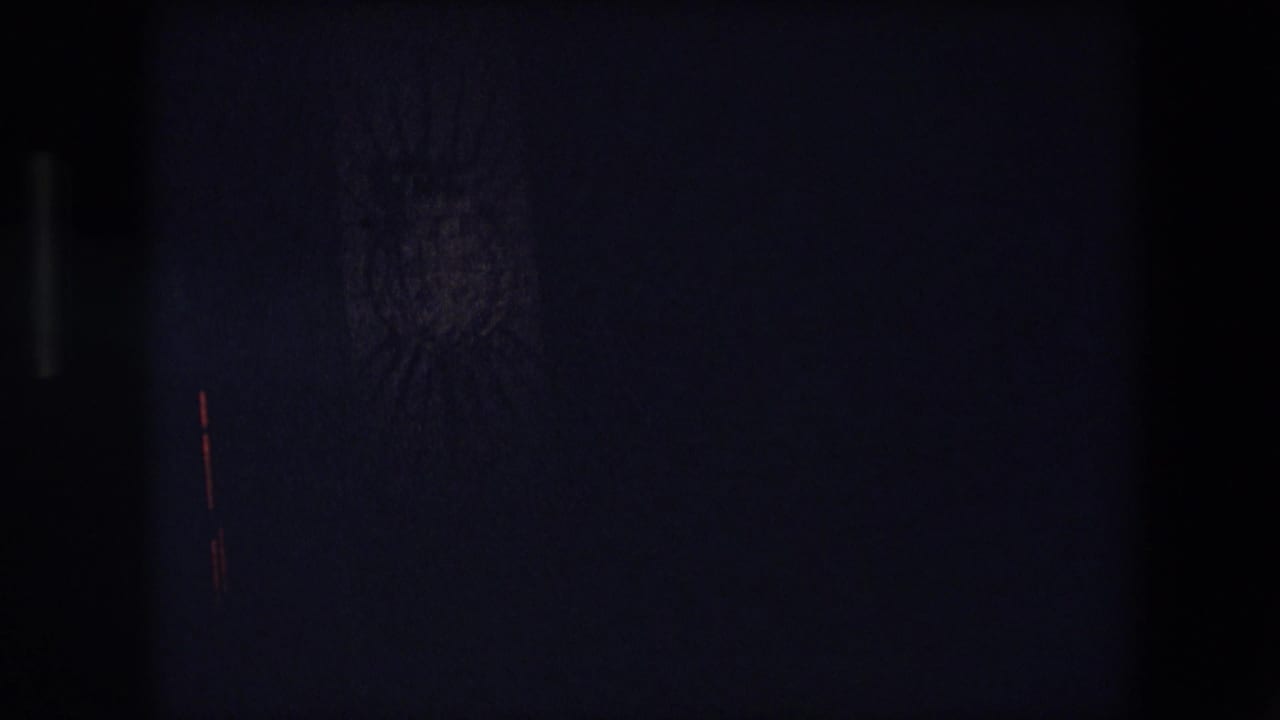 Very dark 1971 Barcelona 8mm frame with only faint vertical bands and small traces of light visible in the underexposed scene.