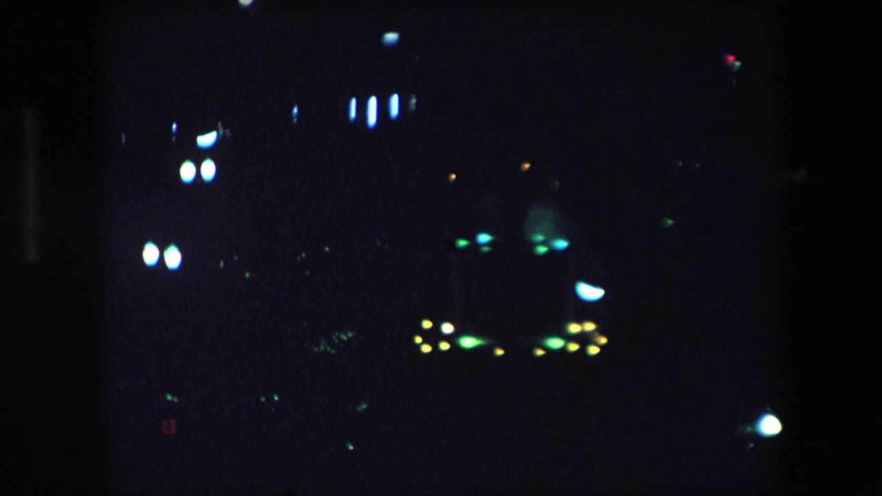 Blurred bright lights scattered across a dark city view.