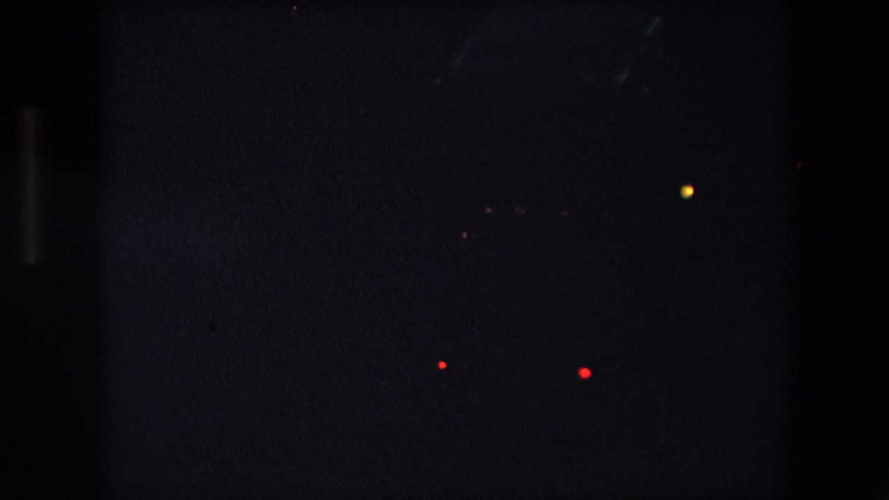 Dark roadway view with scattered red and yellow vehicle lights.