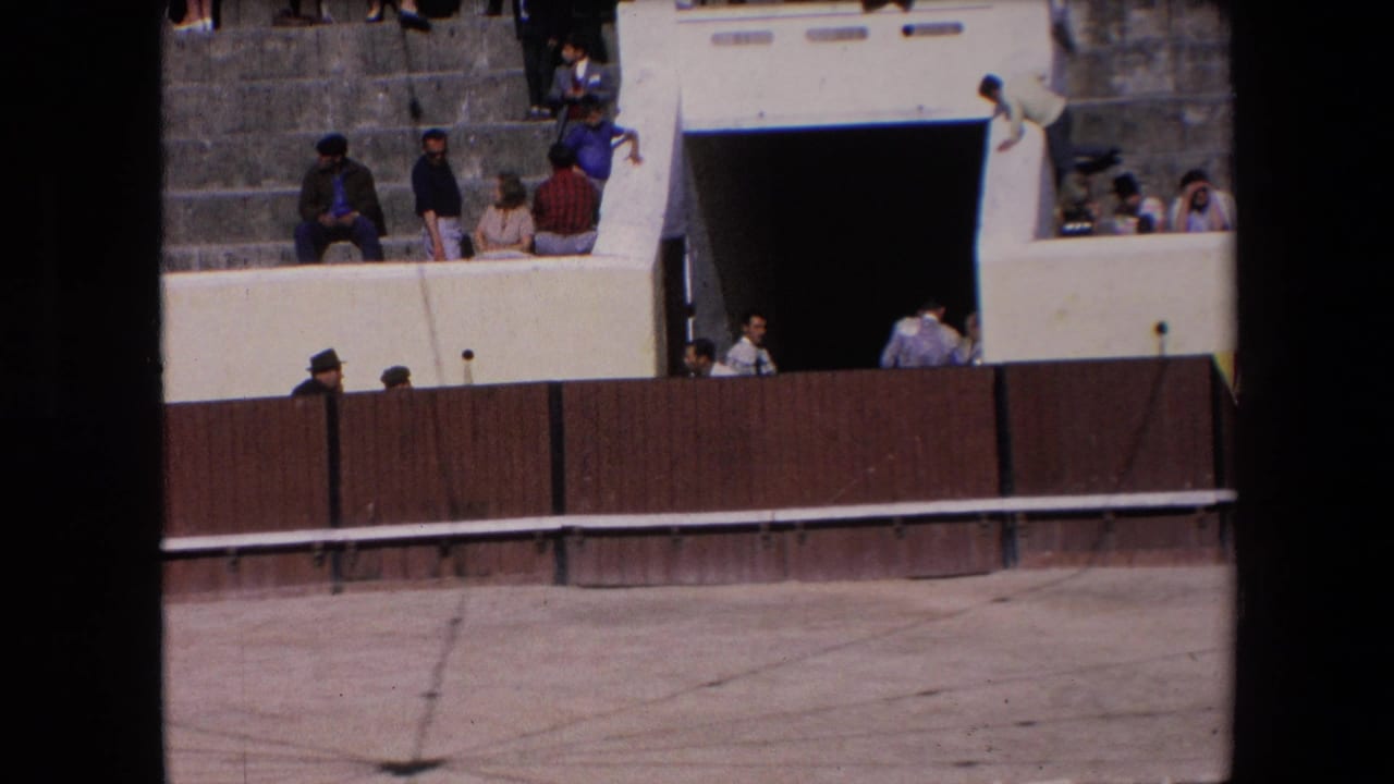 1971 Barcelona bullring view with spectators on stepped seating above a wooden barrier and a dark entrance below.