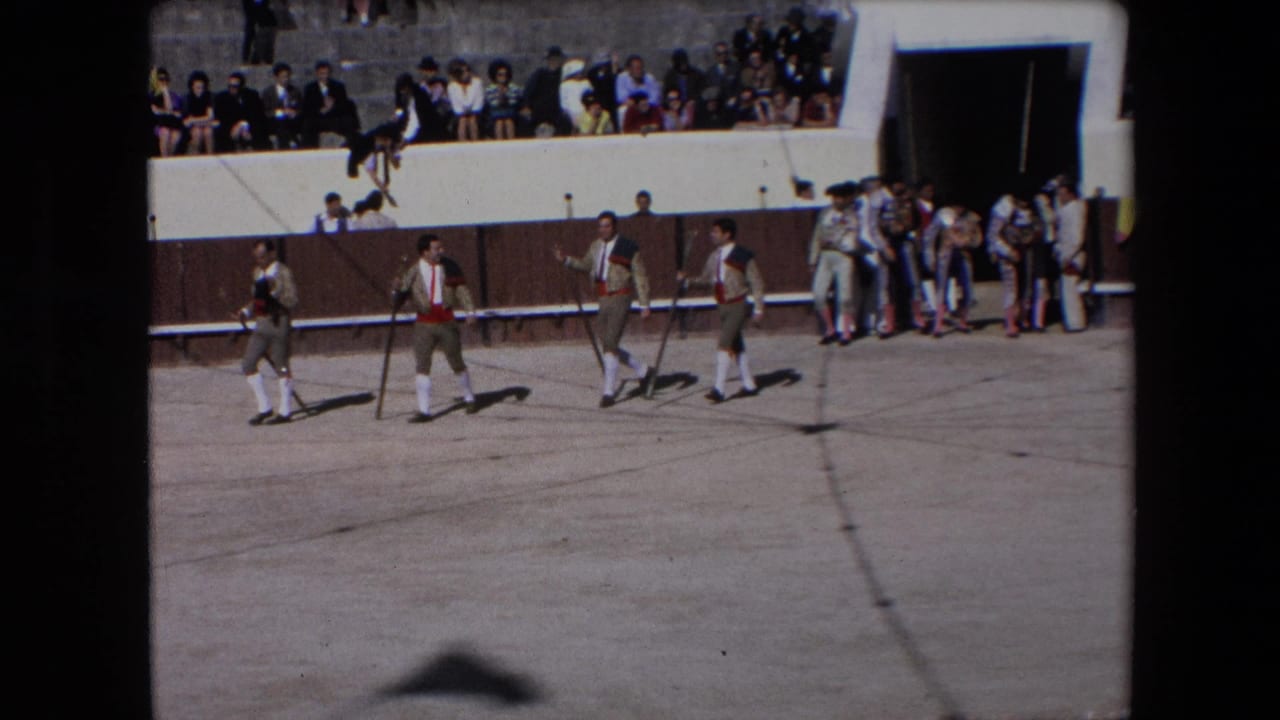 In Barcelona, Spain in 1971, costumed bullfighting participants walk in formation across the arena floor while spectators sit and stand above the ring.