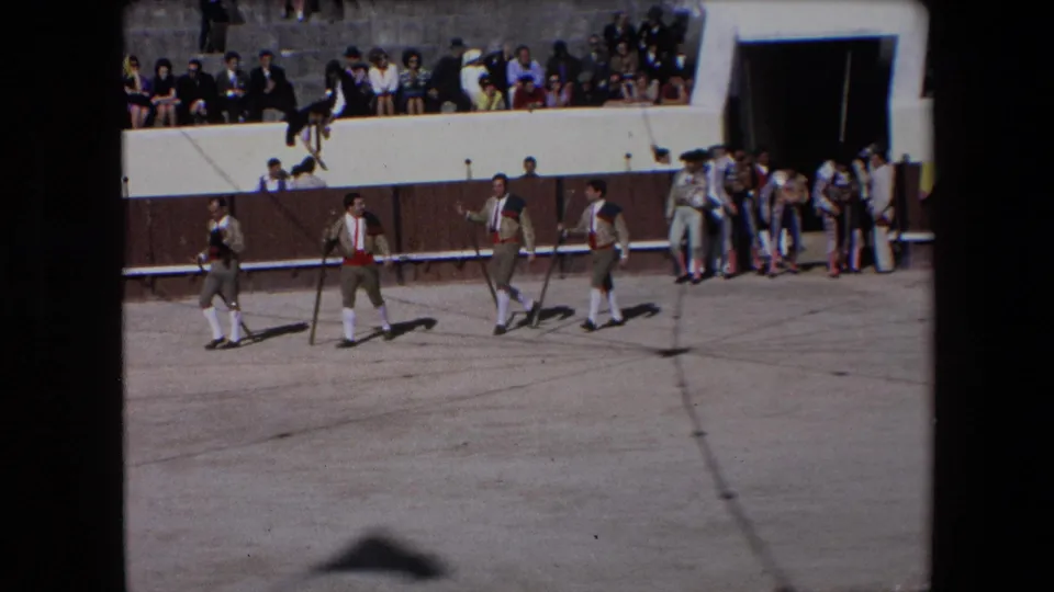 In Barcelona, Spain in 1971, costumed bullfighting participants walk in formation across the arena floor while spectators sit and stand above the ring.