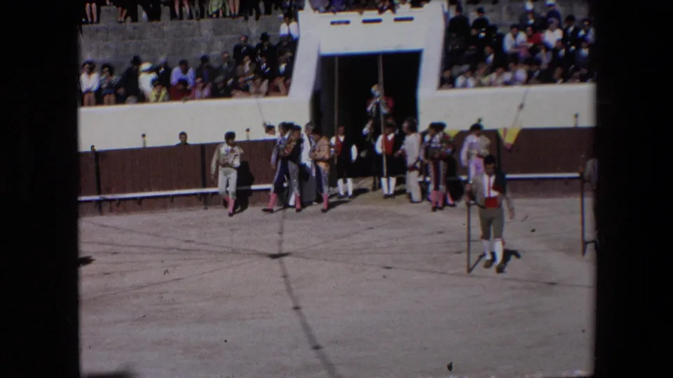 In Barcelona in 1971, costumed participants and attendants cluster near an arena doorway during the bullfighting procession, with spectators visible on the terraces.