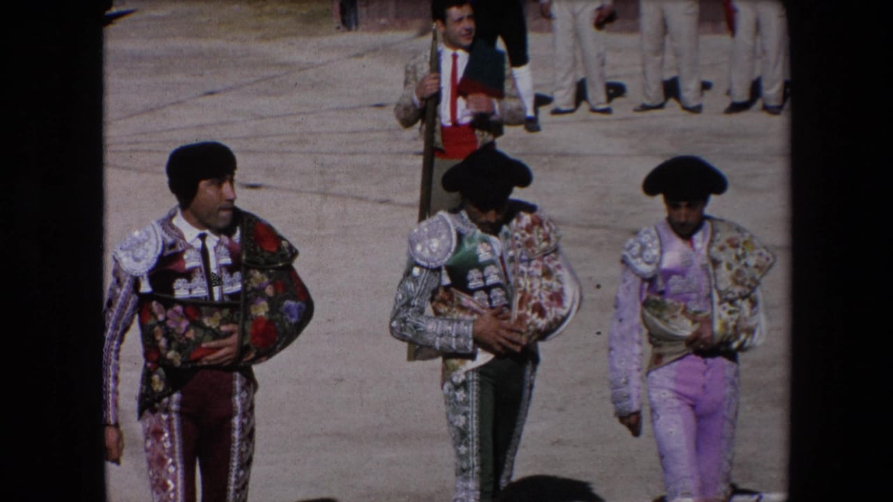 Three matadors pass closer to the camera in a bullfighting arena.