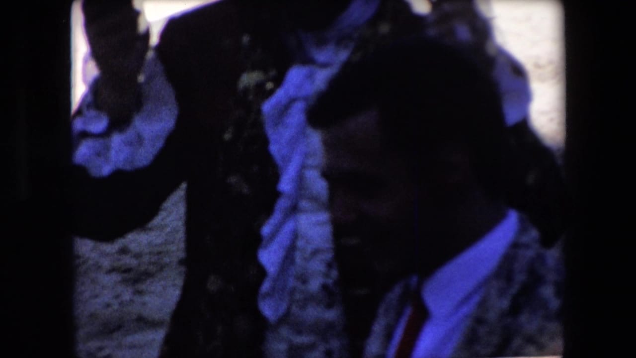 A dim 1971 Barcelona frame shows partially obscured men and a dark bullfighting costume shape near the camera, with blue color cast and heavy shadow.