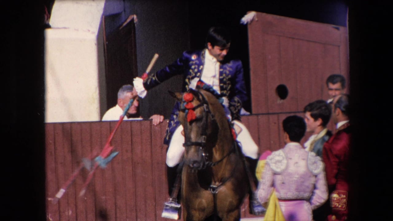In supplied 1971 Barcelona footage, a young bullfighting performer on a decorated brown horse emerges from a wooden gate as costumed men gather beside him.