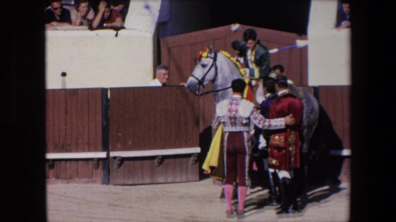 In the 1971 Barcelona bullfighting footage, matadors stand beside a decorated gray horse while spectators look on from the ring enclosure.