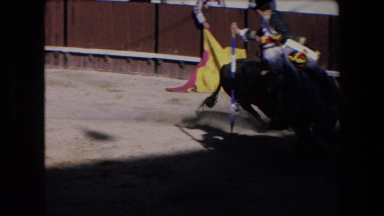 In the supplied 1971 Barcelona bullfighting footage, a black bull moves close to a dark horse and rider while a caped arena figure stands nearby on sandy ground.