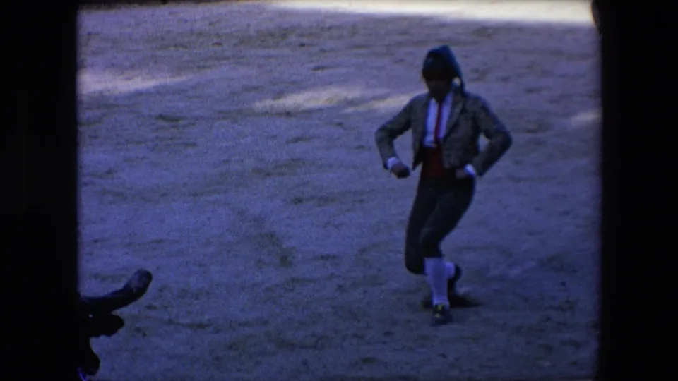 In the 1971 Barcelona arena footage, the matador steps and turns while the dark bull's horns appear at the lower edge of the frame.