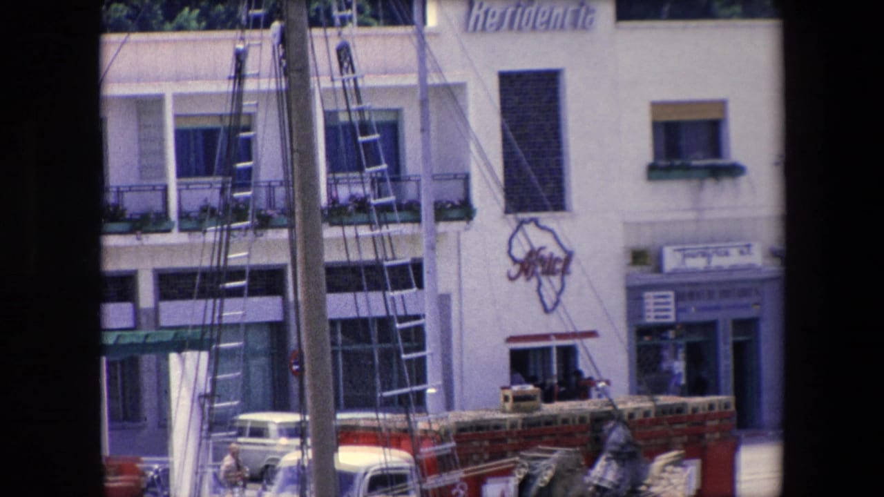 1971 Barcelona waterfront view of the Residencia Africa building area, with boat masts and ladders crossing the foreground and older cars parked near the facade.