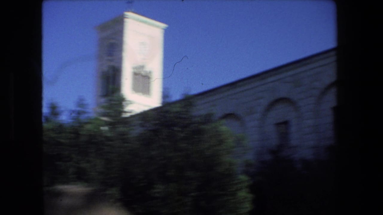 A pale stone building with a tower-like upper section and arched wall detail is seen through a soft 1972 8mm home-movie frame identified in metadata as Tel Aviv, Israel.