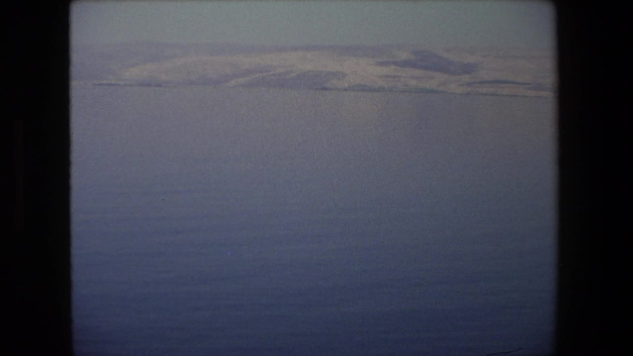 A soft, hazy opening view over water or distant landscape in 1972 Israel travel footage, framed with dark film edges.