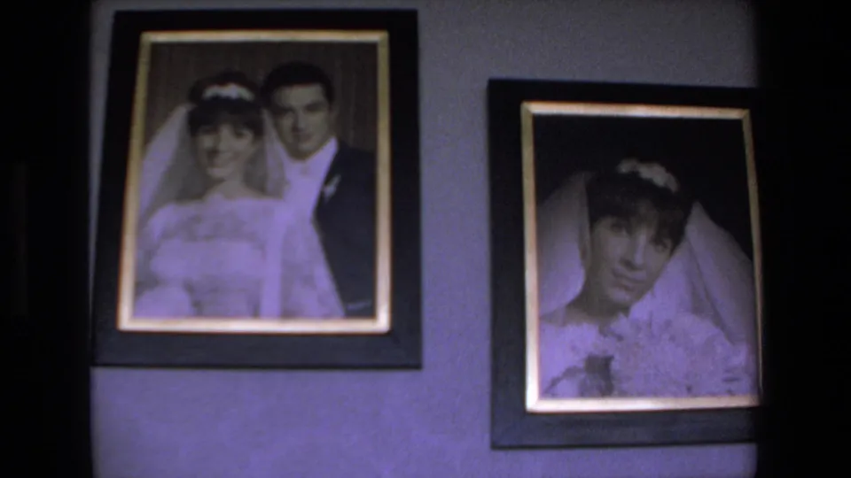Two framed wedding portraits are shown on an indoor wall, including a bride in a veil beside a groom and a separate bridal portrait.