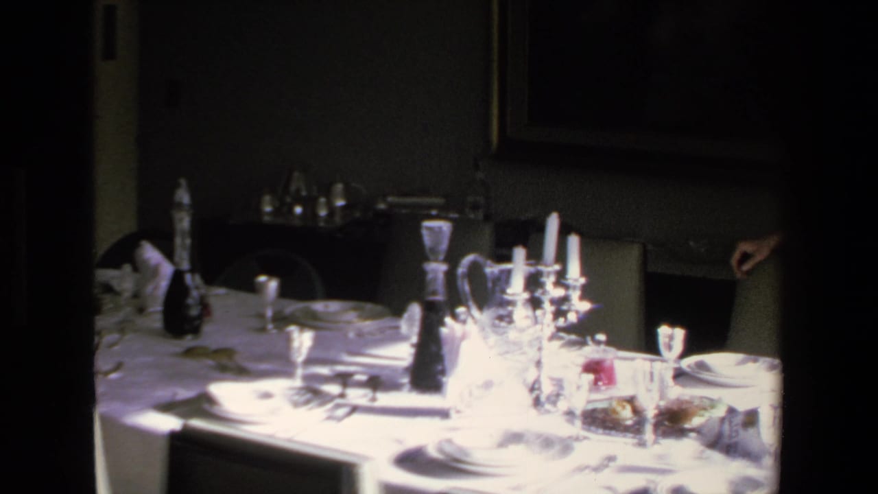 Set dining table with bright glassware and a person partly visible at the right edge.