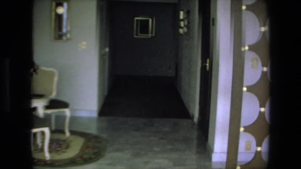 A private home interior in the same 1972 Mazatlan footage shows a hallway, open doorway, chair, wall mirror, patterned flooring, and partial decorative wall elements.
