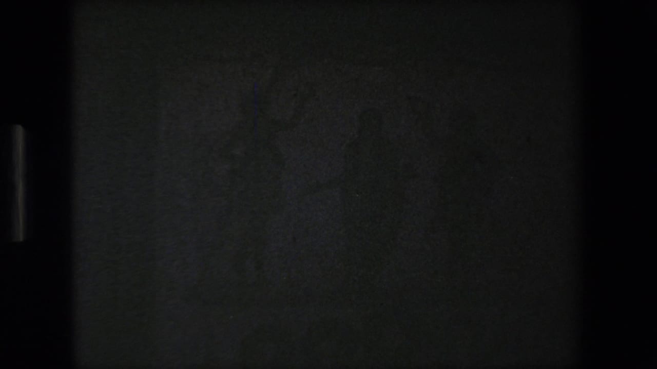 A largely underexposed or black 8mm frame appears between shots, with only faint vertical edge detail visible.
