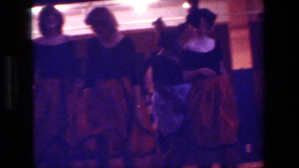 Three adult female dancers appear close together in the dim 1981 Hollywood performance space, with full skirts and black tops visible despite soft focus and low light.