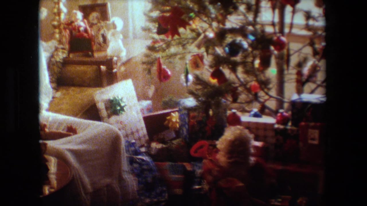 Christmas decorations and gifts beside a tree in a warm living room interior.