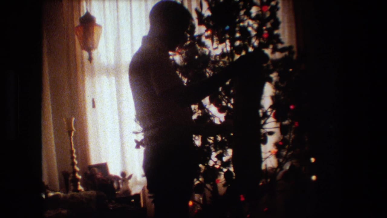 In a 1981 Lansing, Michigan home interior, a silhouetted adult man stands near a decorated Christmas tree backlit by warm window light.