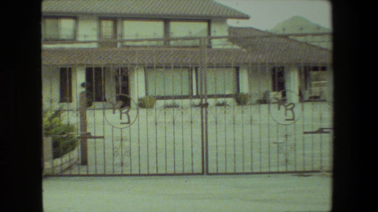 Closer view of the metal gate and front of the stucco house.