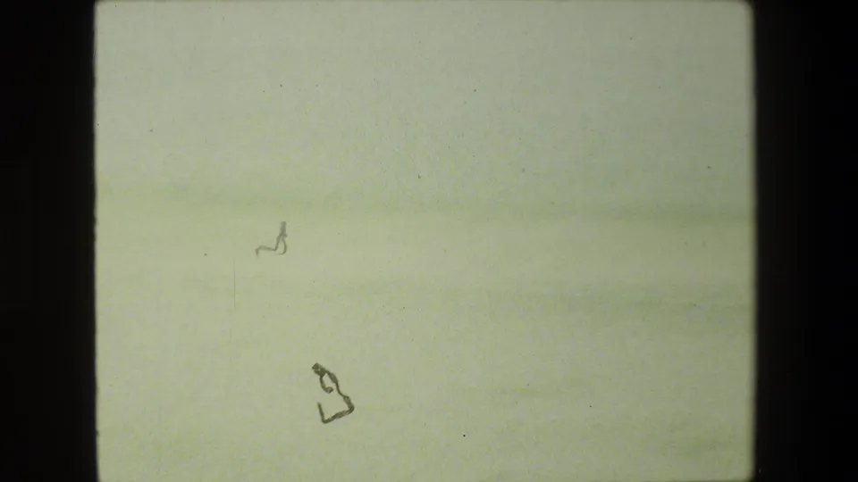 A heavily overexposed 8mm frame from the 1981 Malibu road-trip clip, with faint roadway and roadside forms barely visible through the faded image.