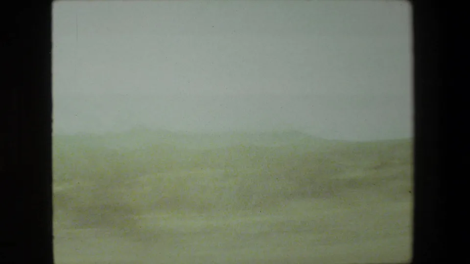 This 1981 Malibu-area frame shows a soft, blurred roadside landscape and low hills, consistent with a moving-car home-movie viewpoint.