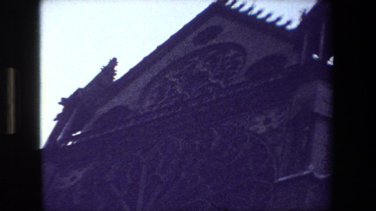 Ornate church roofline and arched stone detail seen from below.