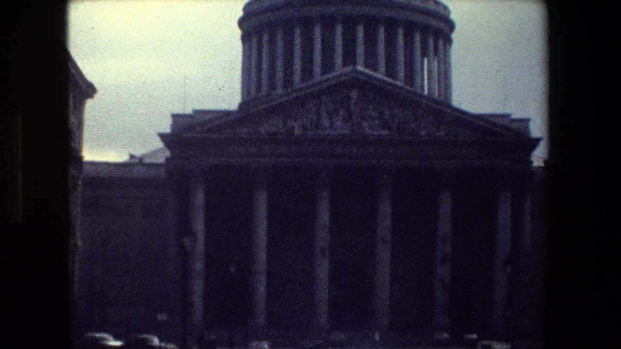 A 1981 Paris home-movie frame shows a large domed neoclassical building with tall columns, seen through dark film-frame edges from across the street.