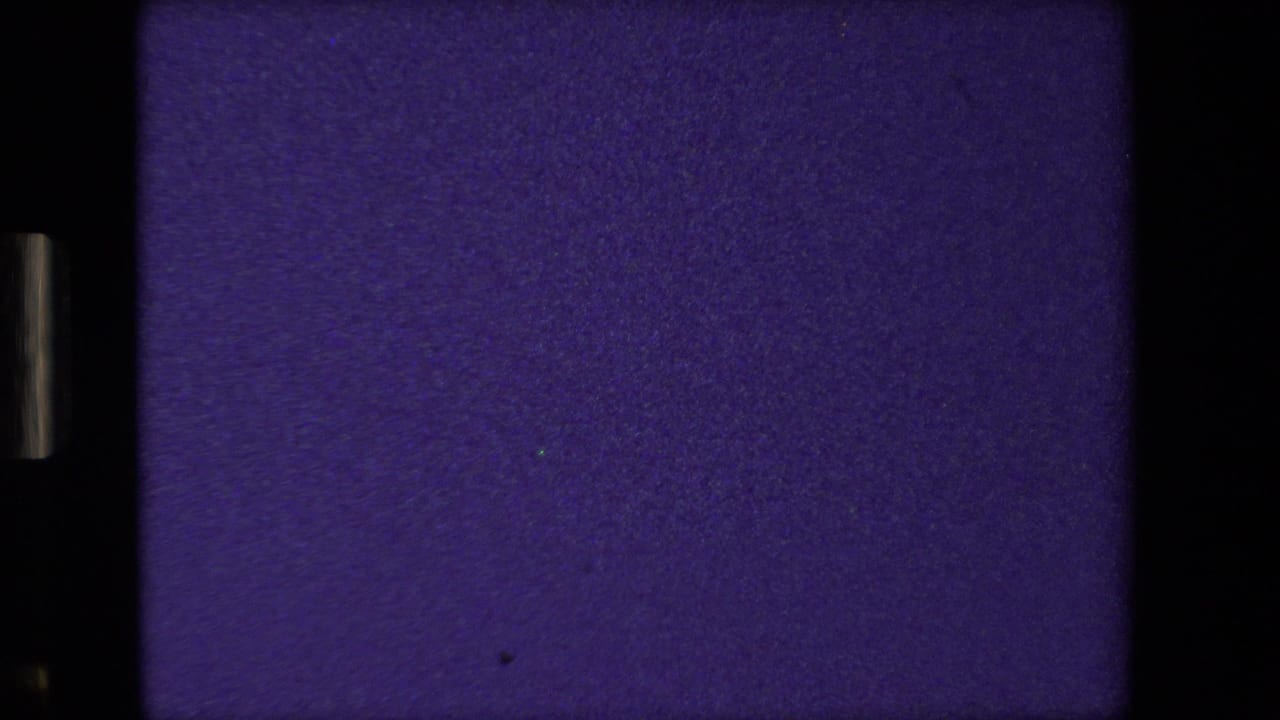Purple-blue 8mm frame at the opening of the 1981 Paris home-movie clip, showing mostly blank exposure or leader-like material with visible film borders.