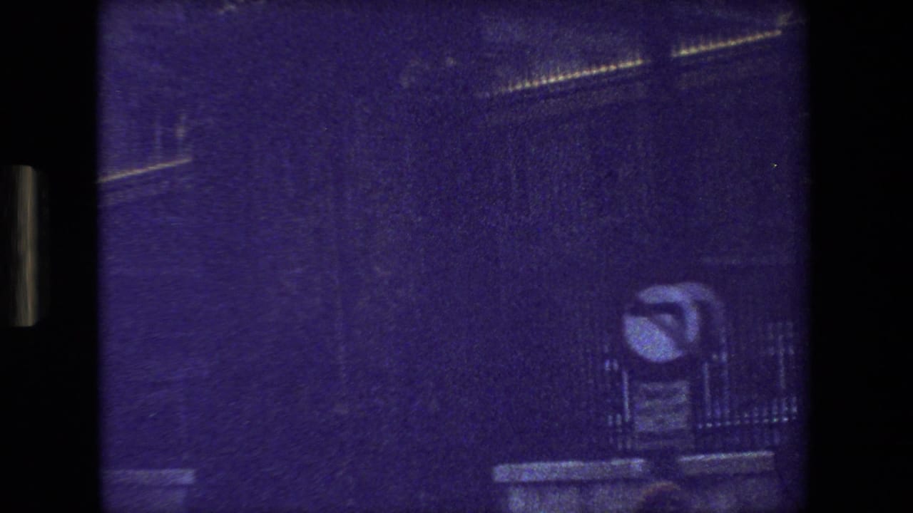 Blurred 1981 Paris travel frame with a purple cast, faint building outlines, and a small possible street fixture visible near the right side.