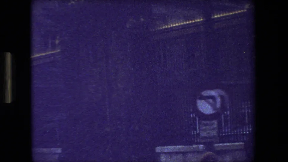 Blurred 1981 Paris travel frame with a purple cast, faint building outlines, and a small possible street fixture visible near the right side.